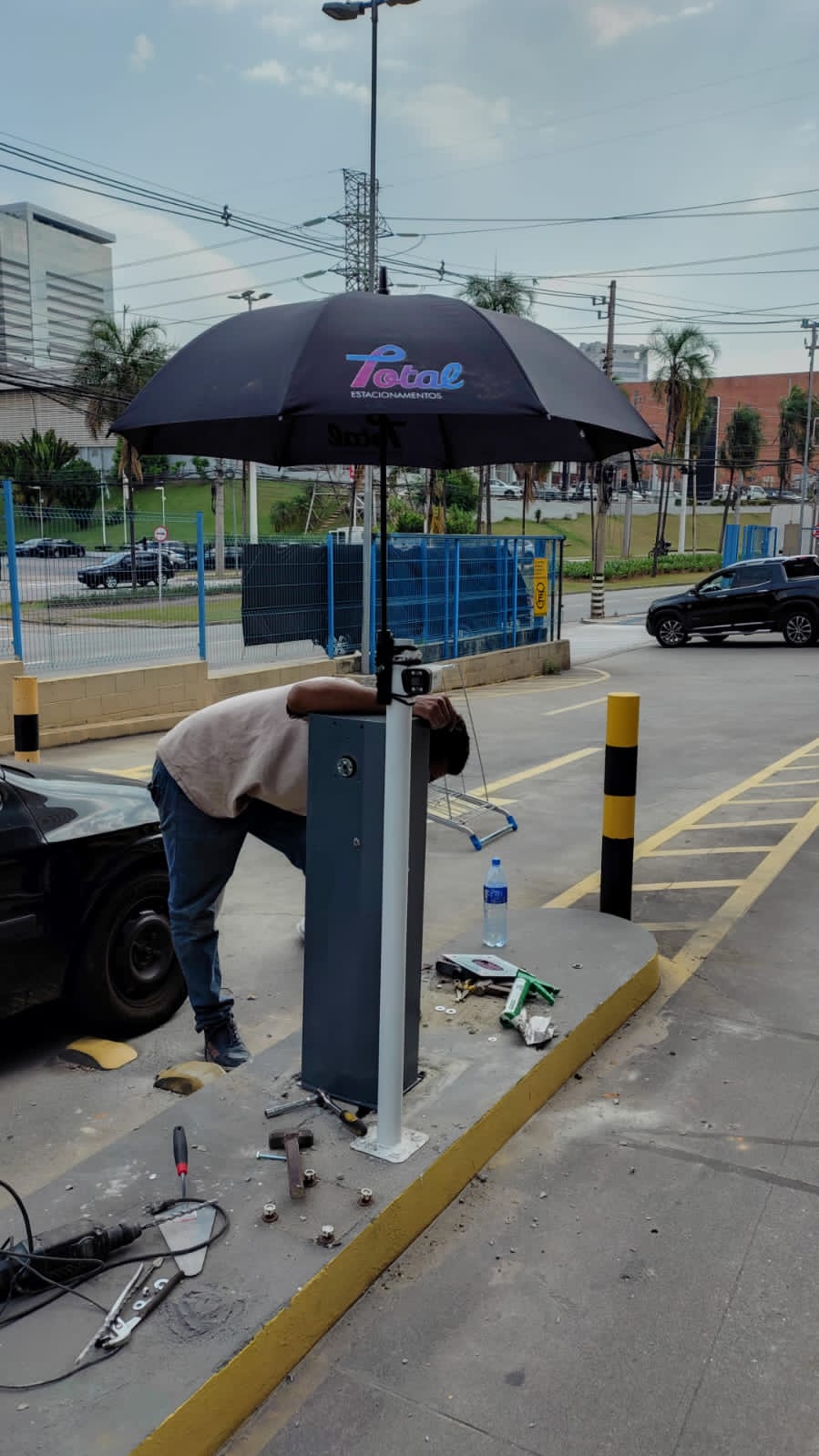 Profissional trabalhando no equipamento de uma cancela instalada