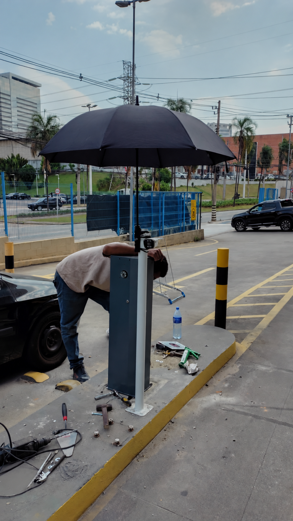 Profissional trabalhando no equipamento de uma cancela instalada